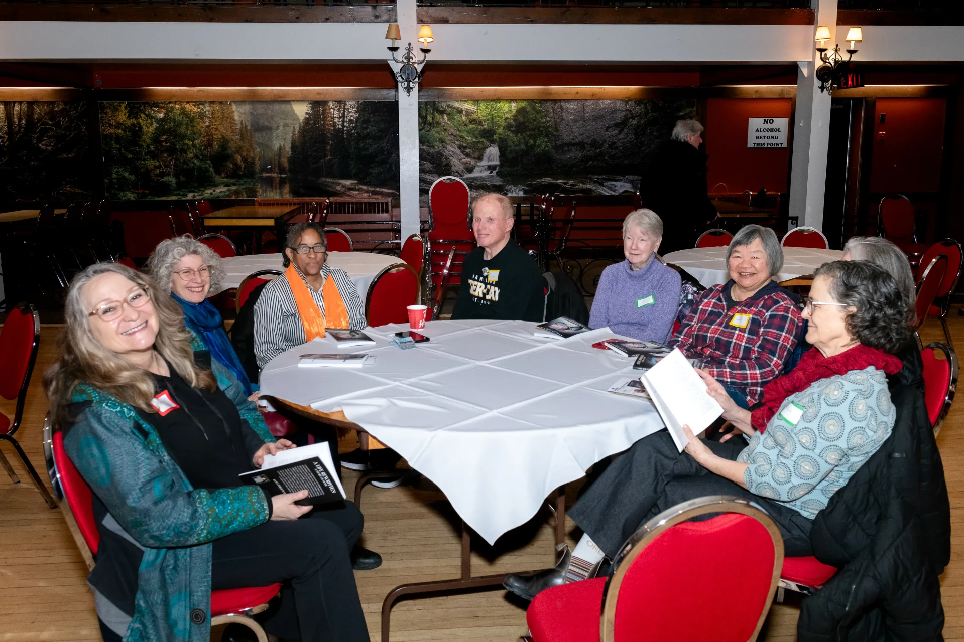 Friends and readers gathered around a table with copies of the book