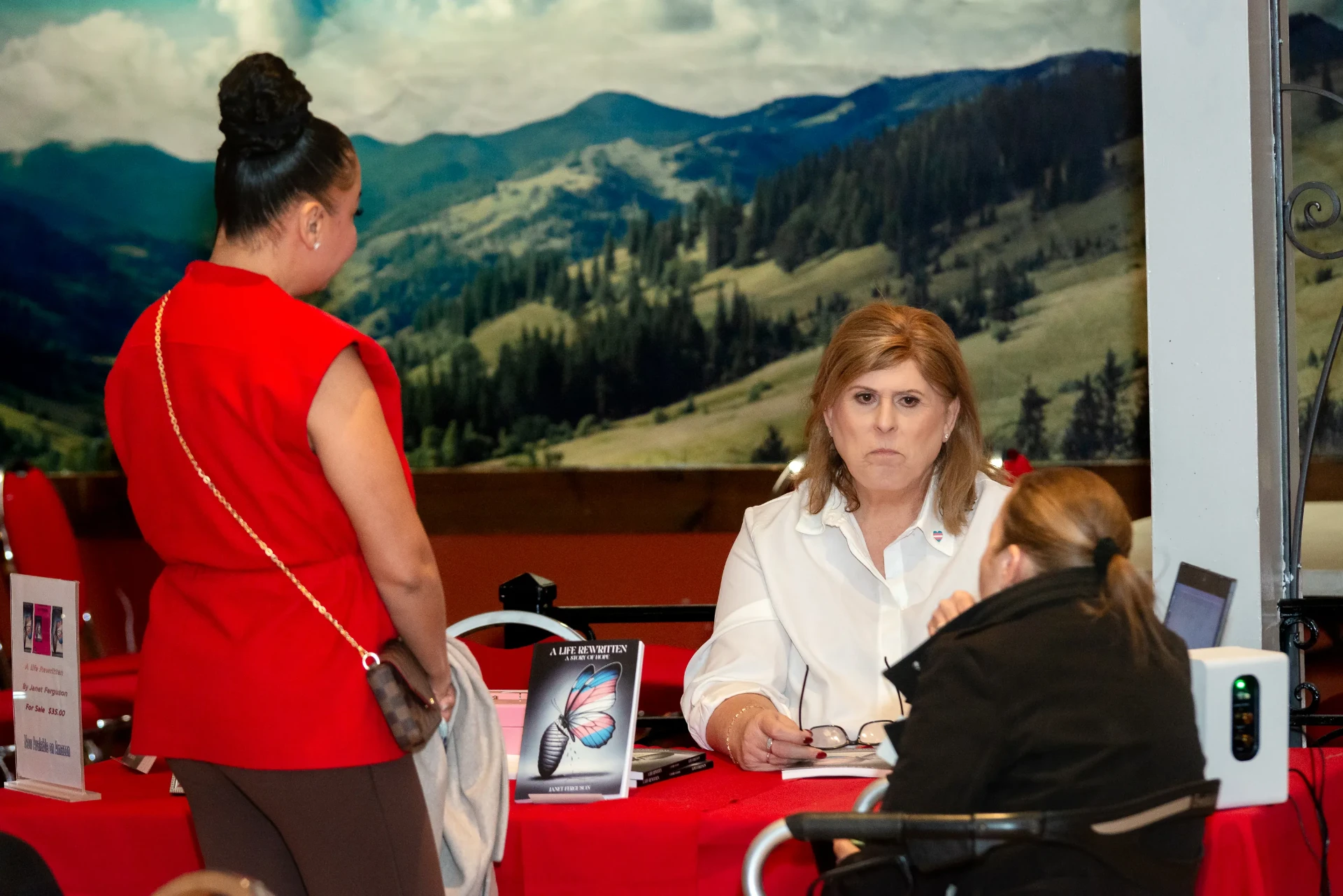 Janet greeting attendees at the signing table