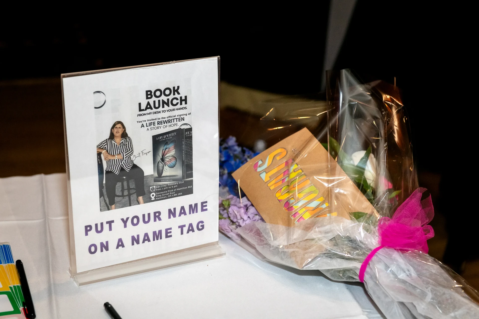 Book launch poster and flowers on the welcome table