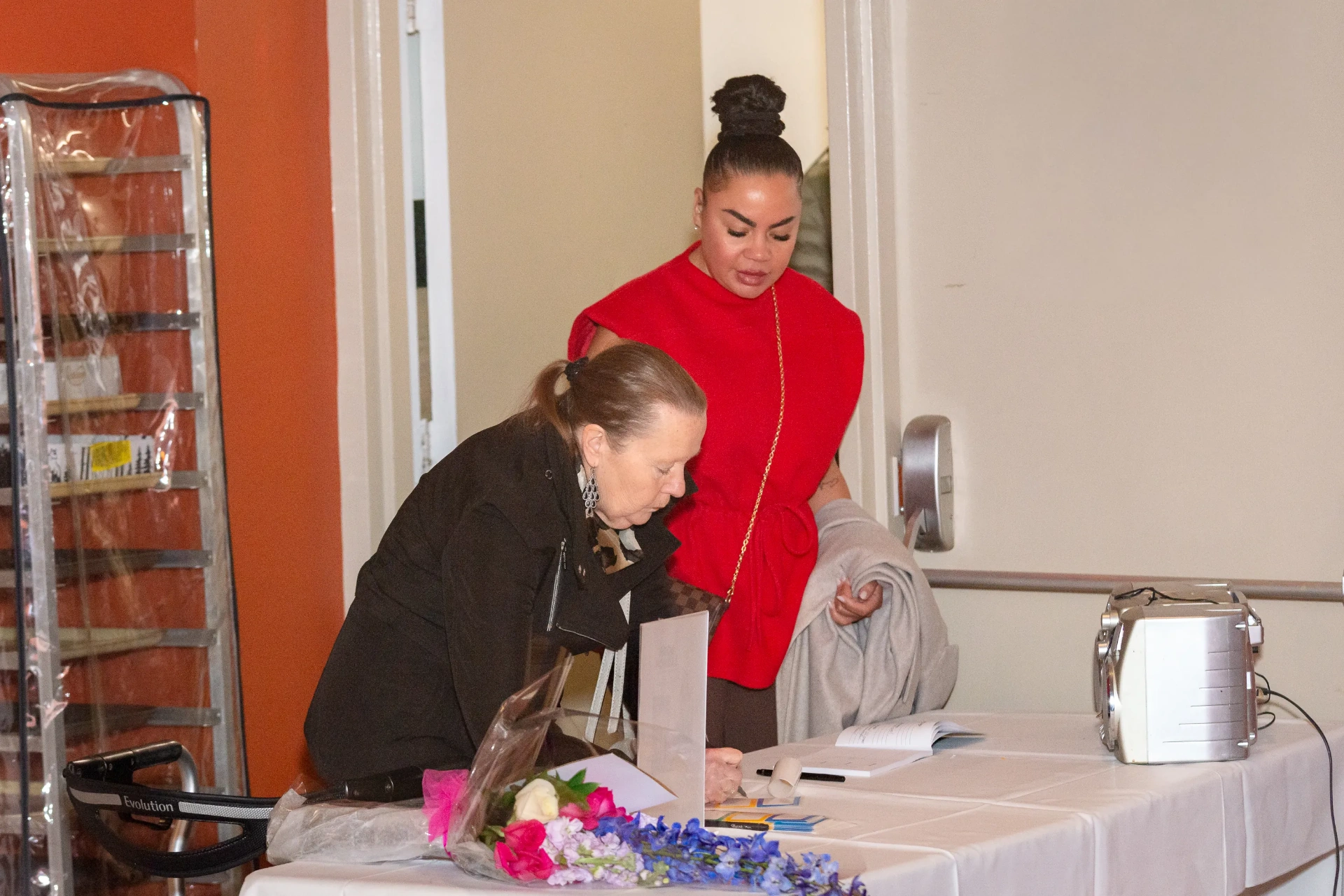 A guest signs in at the welcome table