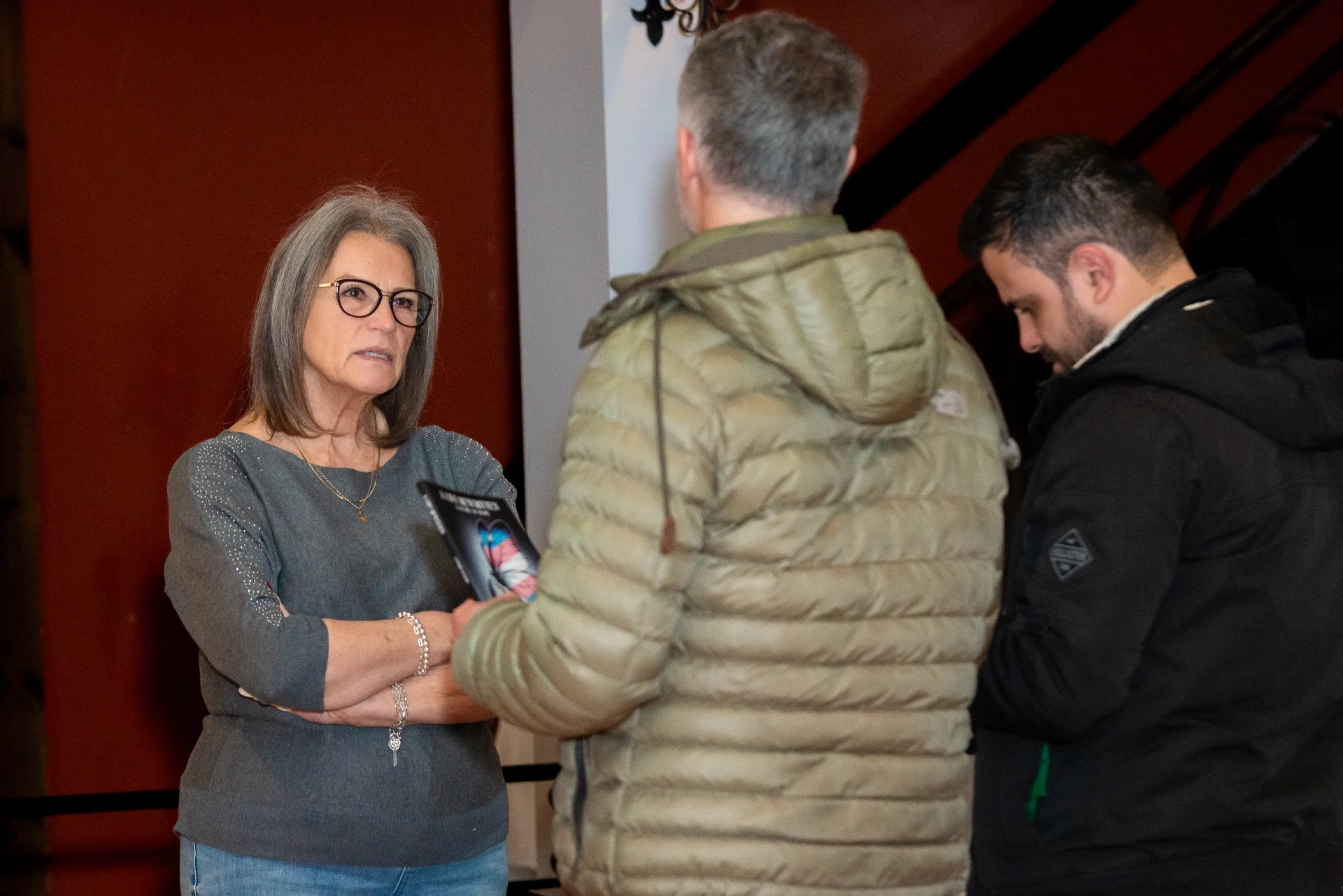 Janet talking with two readers holding her book