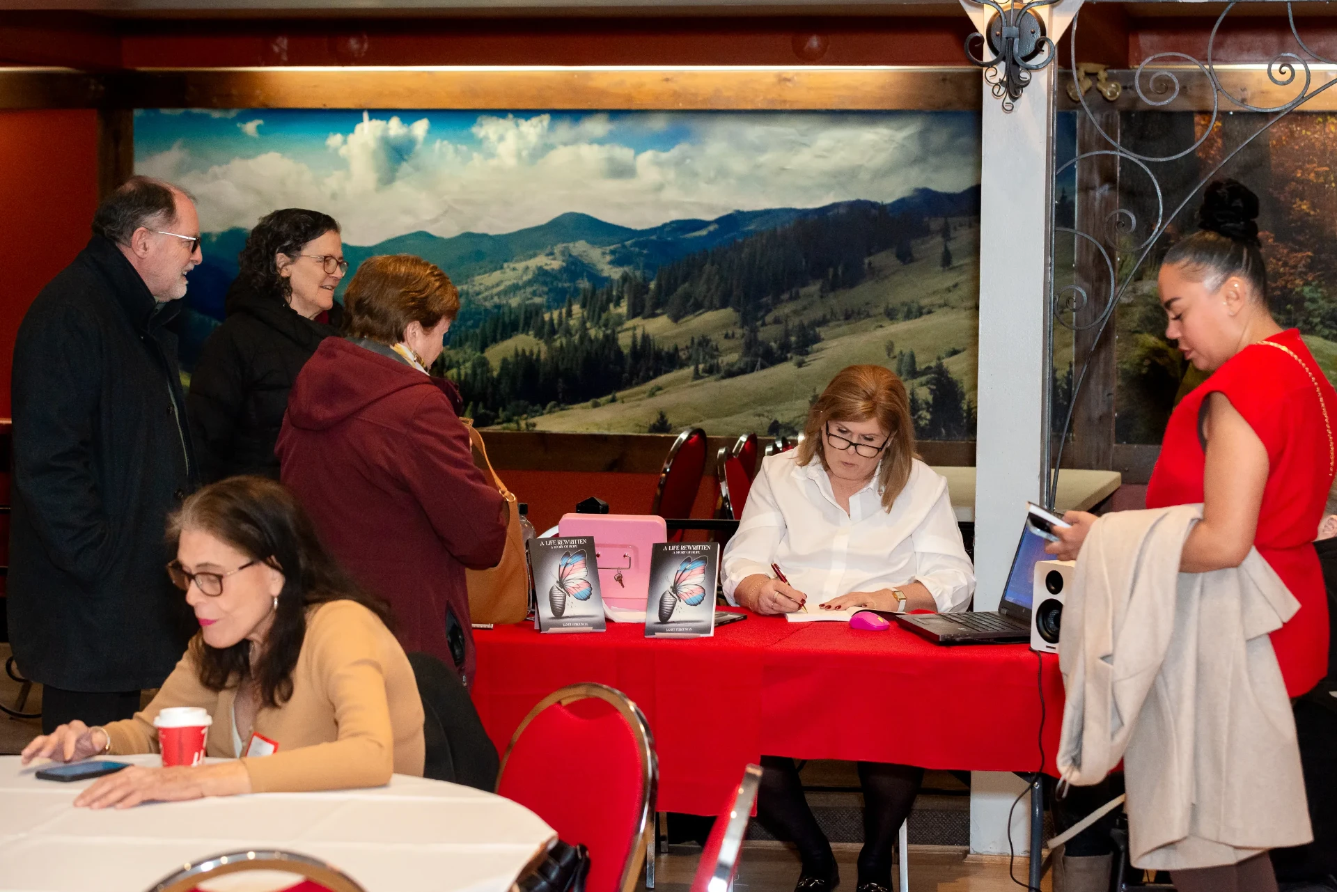 Conversation around the signing table beneath the mural
