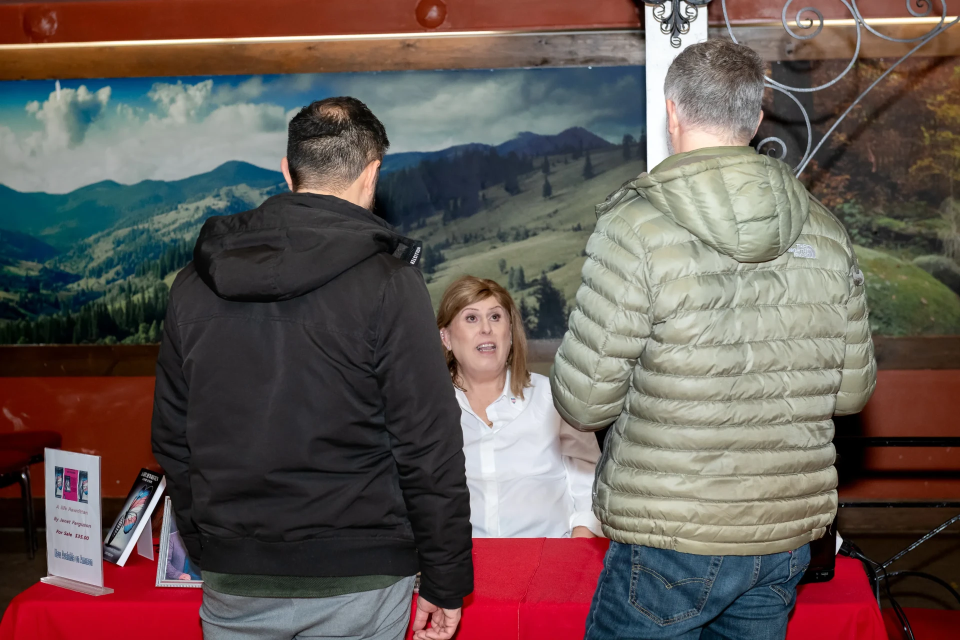 Janet speaking with attendees at the signing table