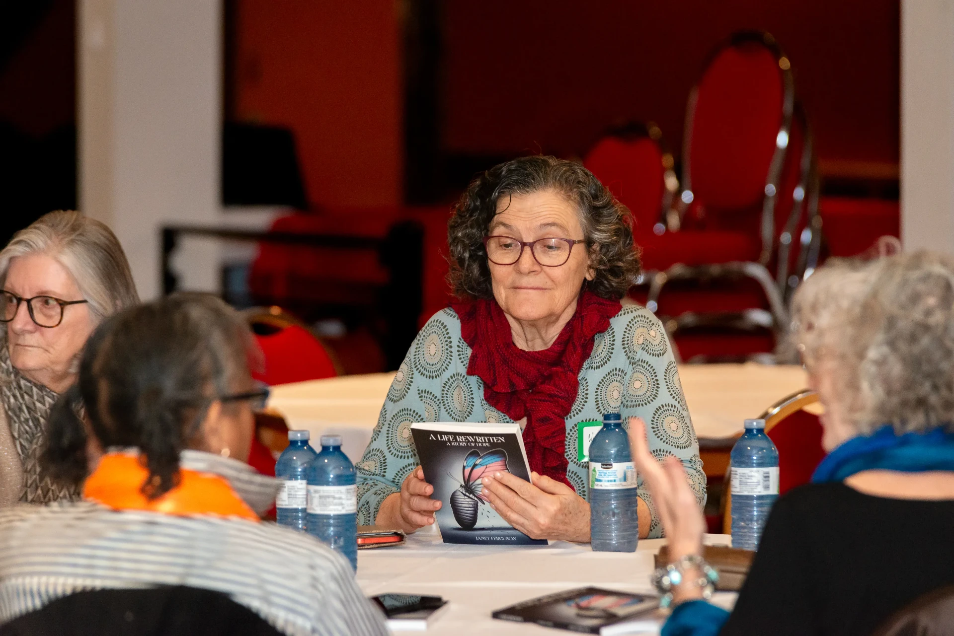A reader looking through A Life Rewritten at her table
